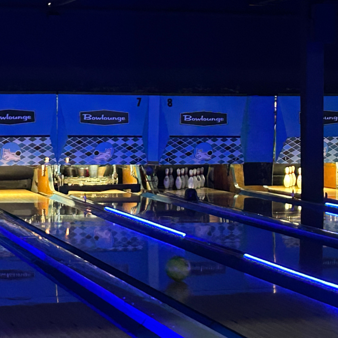 Glowing blue bowling lanes at Bowlounge Dallas, creating a vibrant and immersive bowling experience.