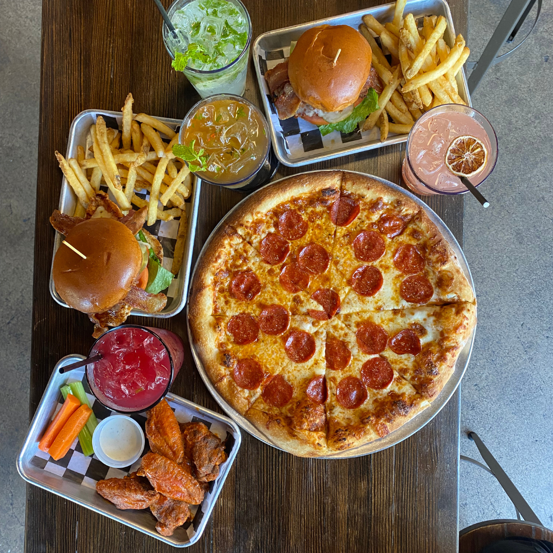 A mouthwatering spread of classic party favorites: cheesy pizza, juicy burgers, crispy wings, and refreshing drinks. Something for everyone at Bowlounge Dallas